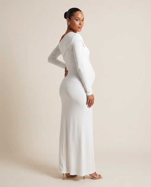 White jersey maternity maxi dress with asymmetric draped shoulder, designed for maternity photoshoots.