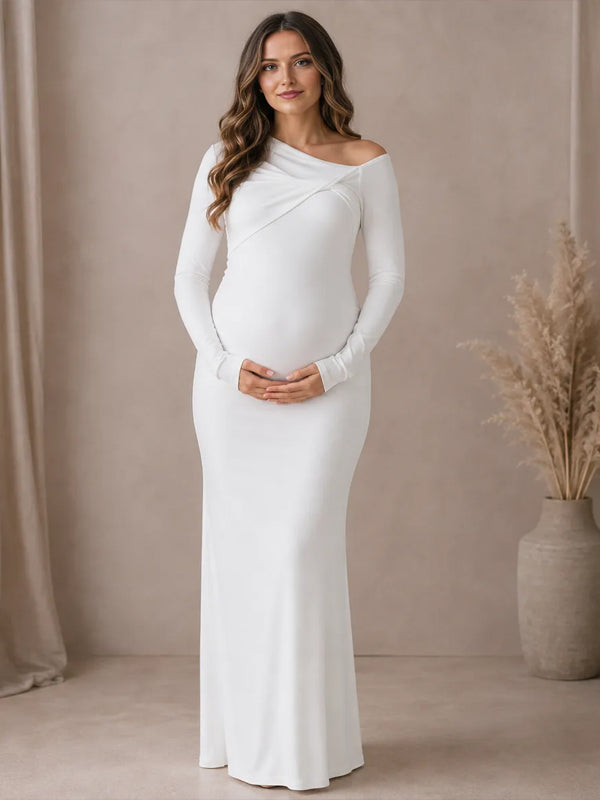 White jersey maternity maxi dress with asymmetric twisted neckline and long sleeves, designed for maternity photoshoot.