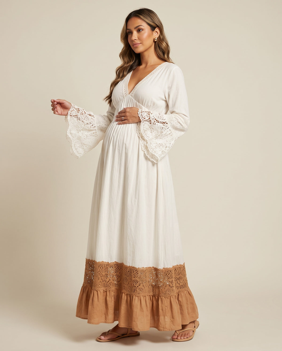 White boho maternity maxi dress with lace bell cuffs and tan lace ruffle hem, designed for maternity photoshoots.