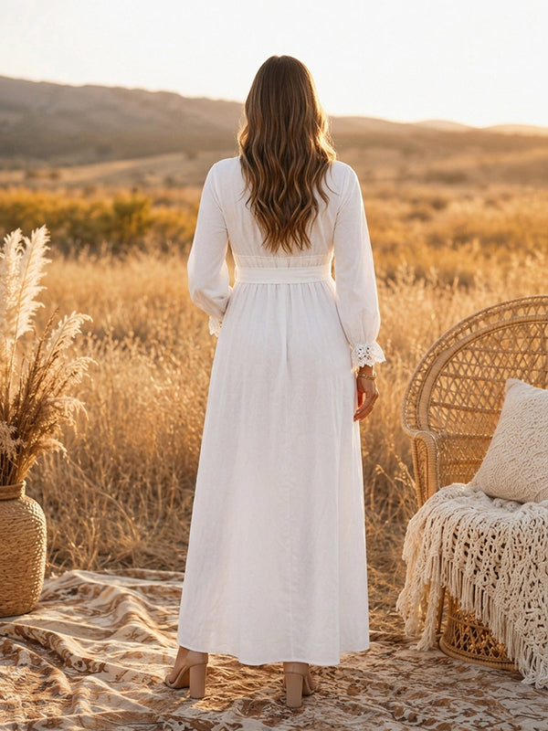 Back view of white boho maternity maxi dress with lace-trimmed V-neck, long sleeves and tie waist, designed for maternity photoshoot.