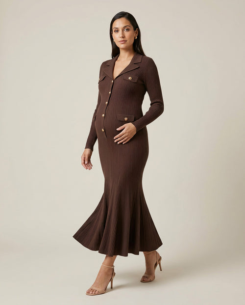 Brown ribbed knit maternity maxi dress with collar, gold buttons and fluted hem, shown on a pregnant model in studio.