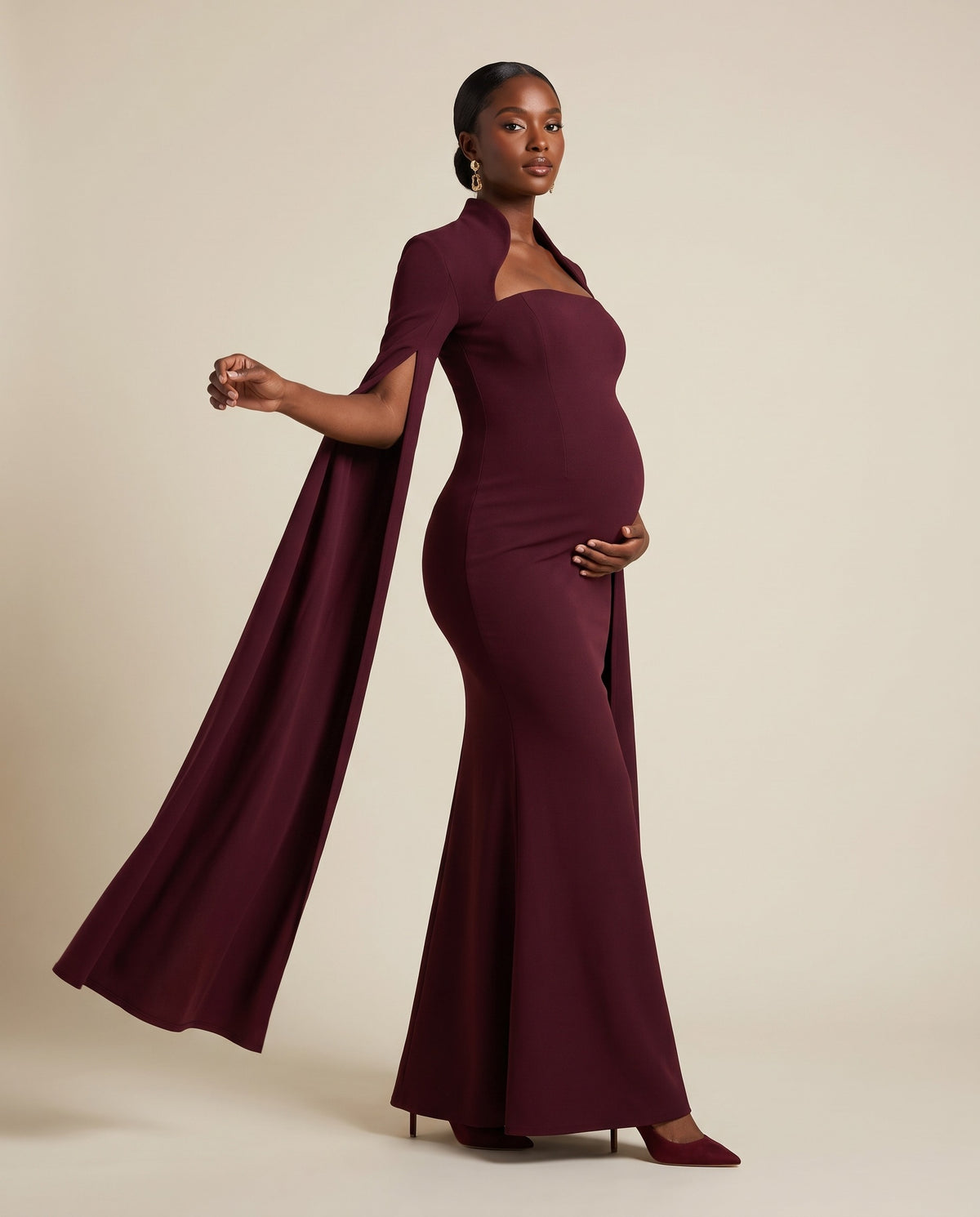 Burgundy maternity mermaid gown with attached cape, designed for baby showers and evening wear.