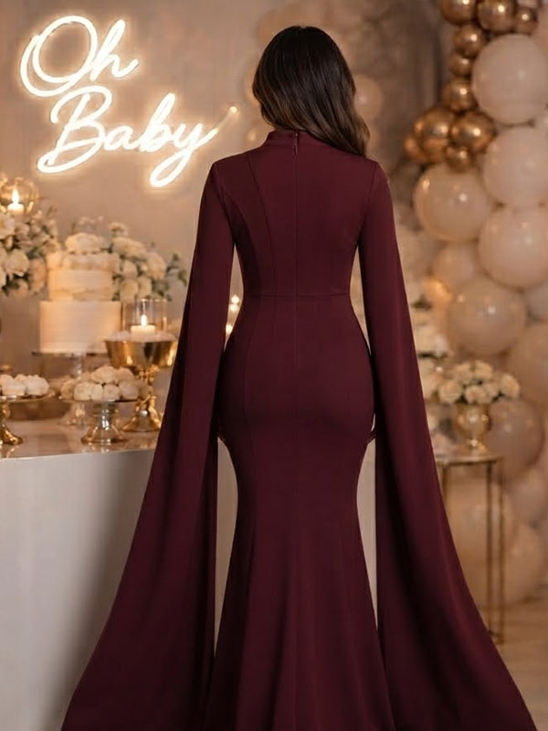Back view of burgundy strapless mermaid maternity maxi dress with long slit-sleeve cape jacket, designed for baby shower.