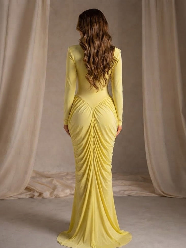 Back view of yellow ruched maternity maxi dress with crossed chest cut-out, mock neck and long sleeves, designed for maternity photoshoot.