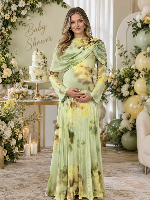 Sage green floral print satin maternity maxi dress with draped cape scarf and bell sleeves, designed for baby shower.