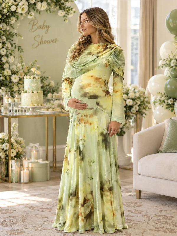 Sage green floral print satin maternity maxi dress with draped cape scarf and bell sleeves, designed for baby shower.