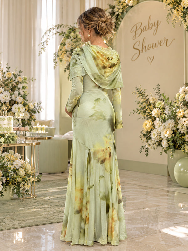 Back view of sage green floral print satin maternity maxi dress with draped cape scarf and bell sleeves, designed for baby shower.