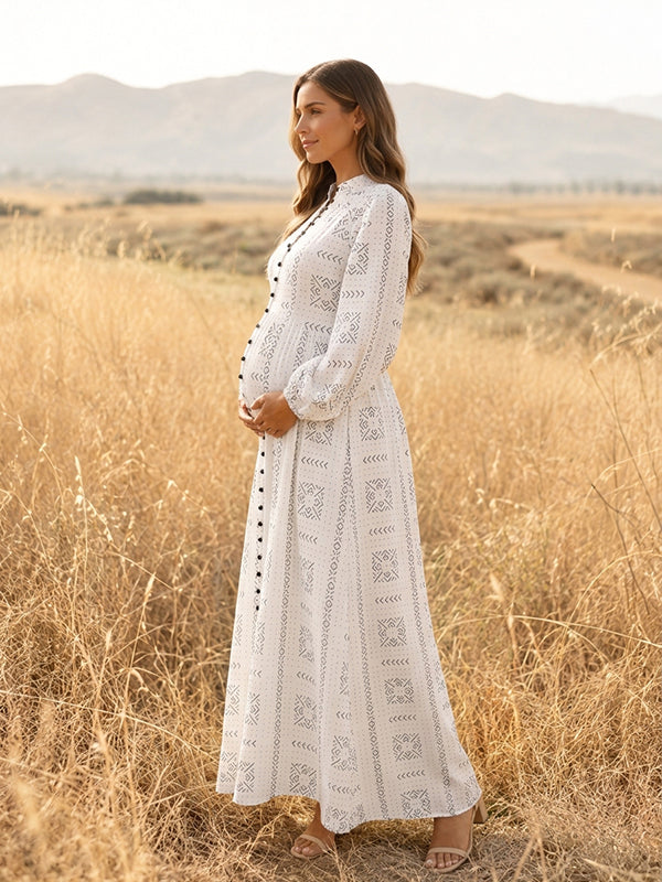 Side view of white eyelet embroidered maternity maxi dress with band collar, button front and long sleeves, designed for maternity photoshoot.