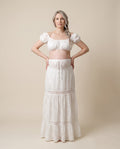 White cotton eyelet maternity two-piece set with puff sleeve crop top and tiered lace skirt, designed for maternity photoshoots.