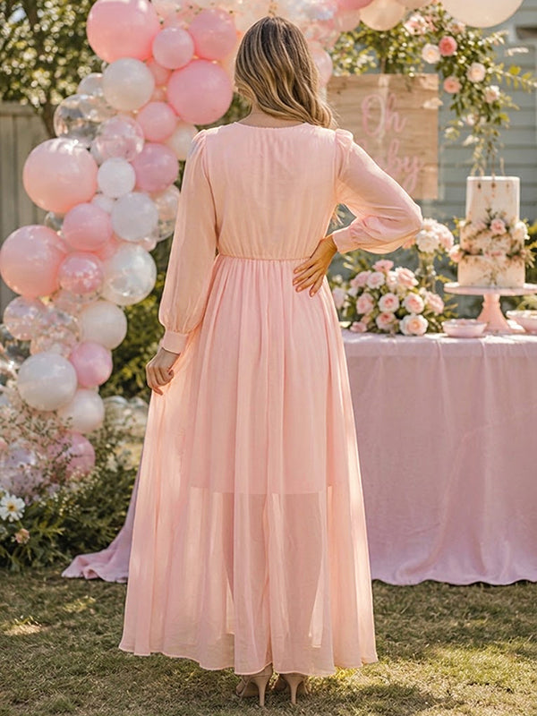 Back view of blush pink chiffon maternity maxi dress with V-neck, sheer long sleeves and floral embroidery, designed for baby shower.