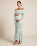 Mint green mesh maternity maxi dress with ivory floral lace appliques and off-shoulder fold-over neckline, shown on a pregnant model in studio.