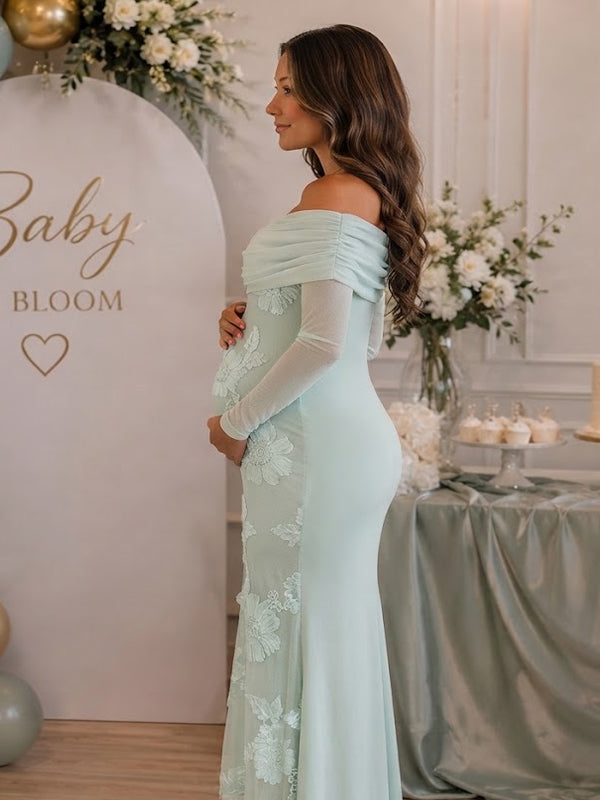 Side view of mint green maternity maxi dress with off-shoulder fold, sheer sleeves and floral embroidery on mesh, designed for baby shower.