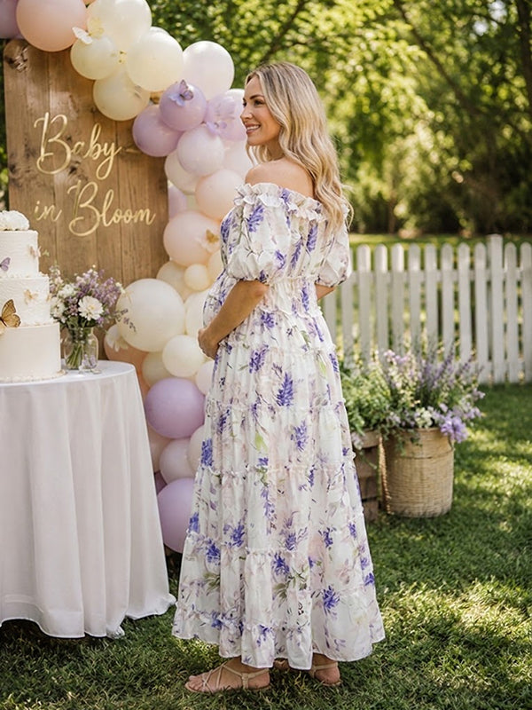 Side view of white and lavender floral maternity maxi dress with off-shoulder neckline, puff sleeves, smocked bodice and tiered skirt, designed for baby shower.