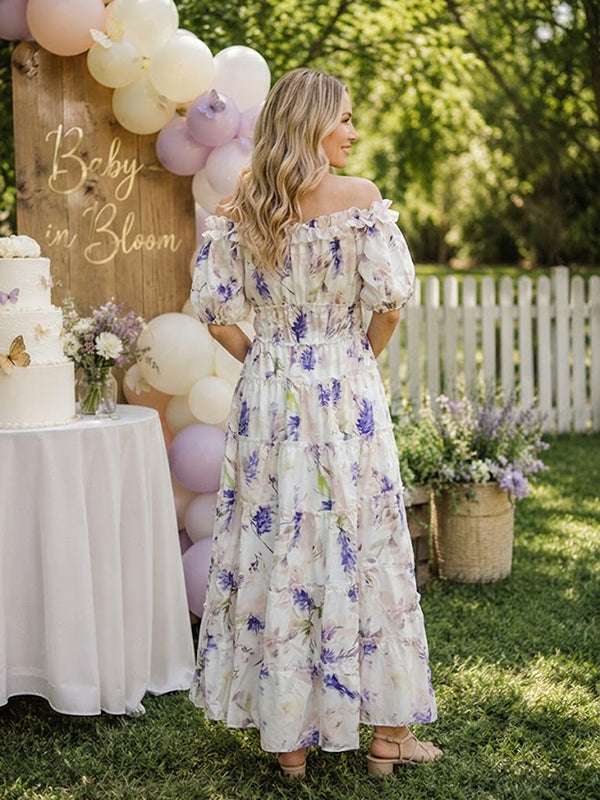 Back view of white and lavender floral maternity maxi dress with off-shoulder neckline, puff sleeves, smocked bodice and tiered skirt, designed for baby shower.