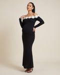 Black off-shoulder maternity maxi dress with ivory floral trim neckline, designed for evening and party wear.