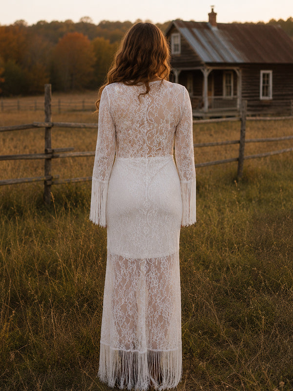 Back view of white lace maternity maxi dress with deep V-neck, fringed bell sleeves and fringe hem, designed for maternity photoshoot.