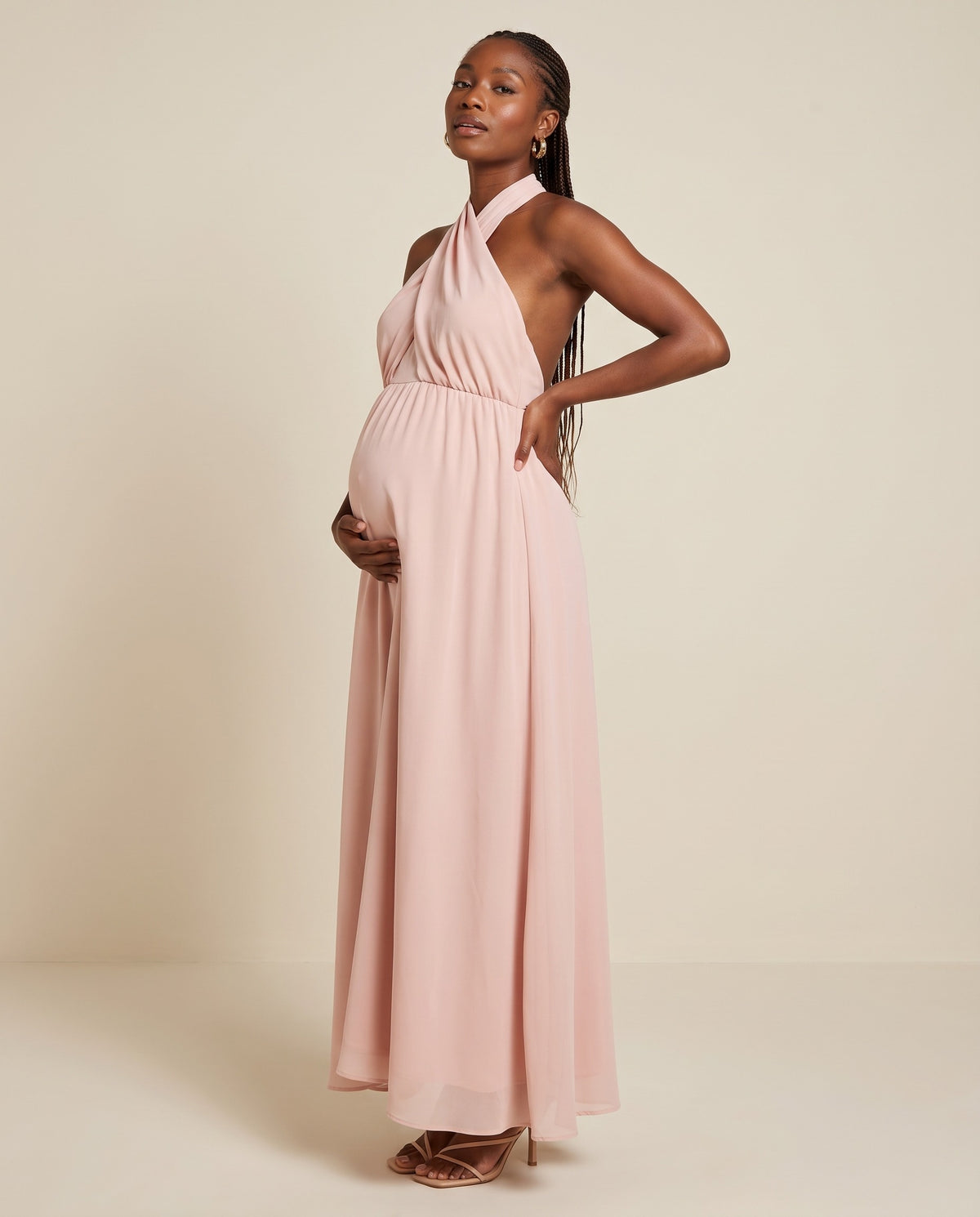 Pink flowing maternity maxi dress with crossed halter neckline, designed for baby showers.