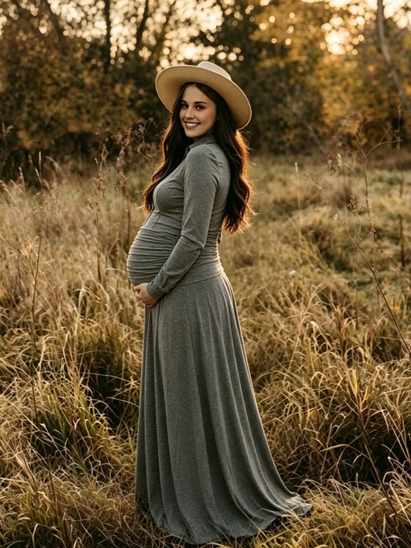 Side view of grey jersey maternity maxi dress with collar, button placket, ruched waist and flowy skirt, designed for maternity photoshoot.