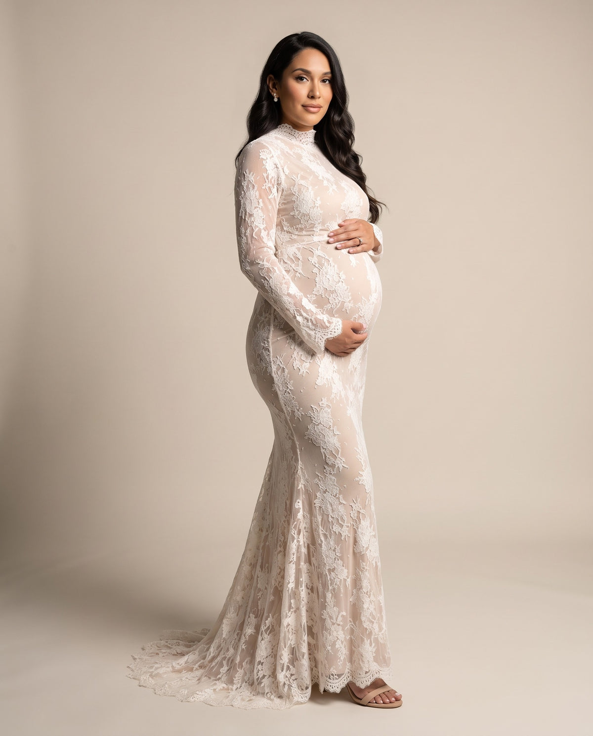 Ivory corded lace maternity mermaid gown with high mock neck and long sleeves, shown on a pregnant model in studio.