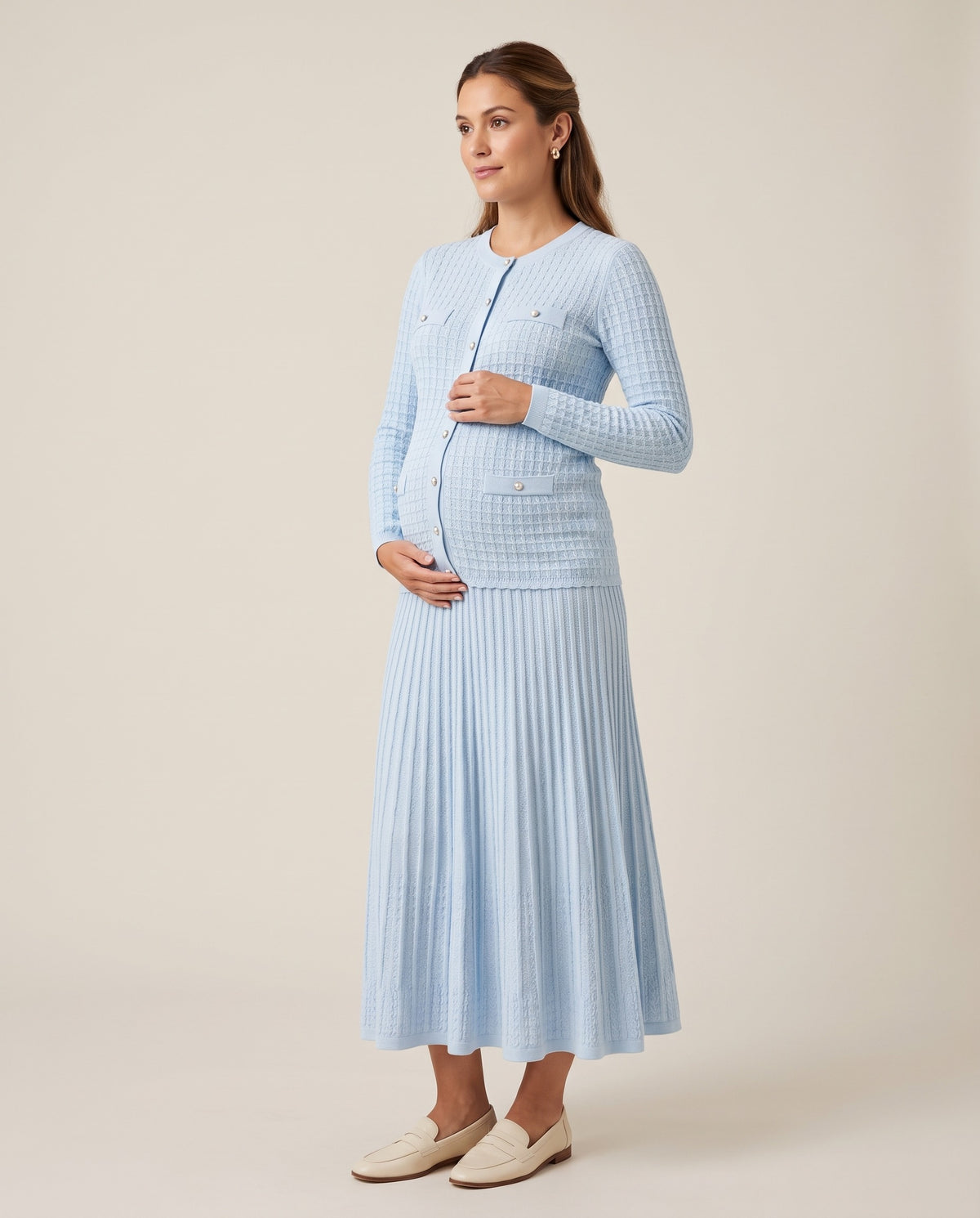 Light blue knit maternity two-piece set with button cardigan and pleated midi skirt, designed for everyday and photoshoot wear.