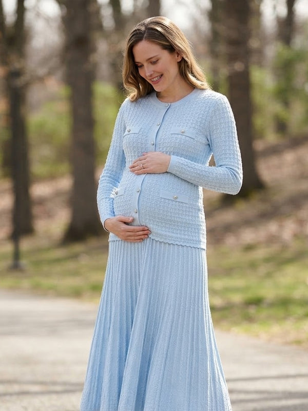 Light blue knit maternity two-piece set with button cardigan and pleated maxi skirt, designed for maternity photoshoot.