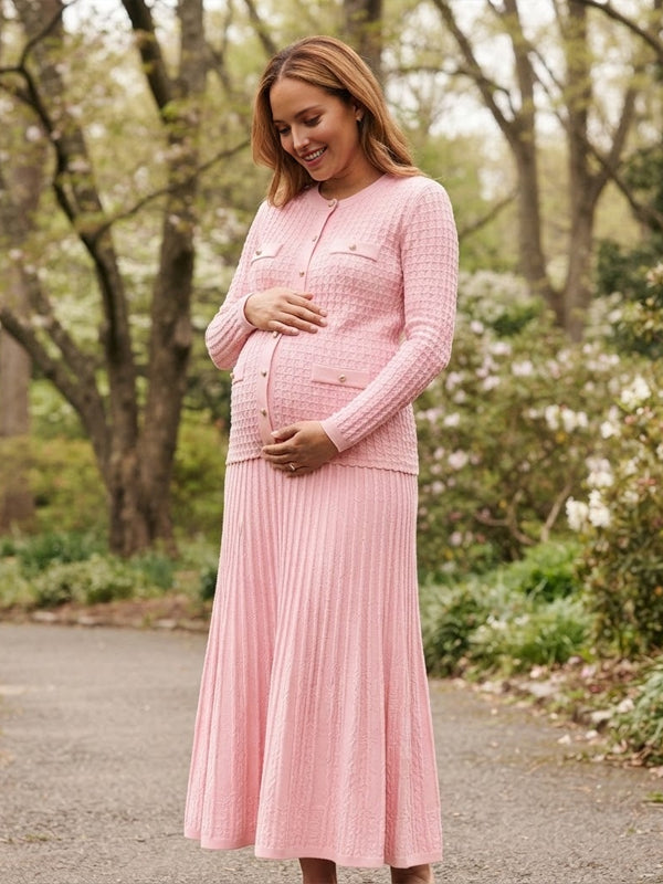 Pink knit maternity two-piece set with button cardigan and pleated maxi skirt, designed for maternity photoshoot.