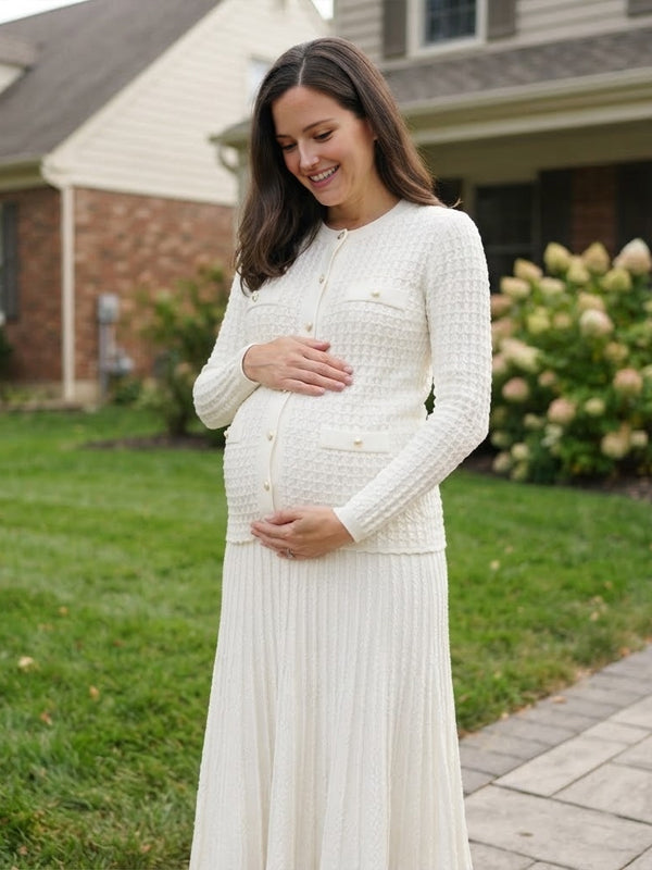 White knit maternity two-piece set with button cardigan and pleated maxi skirt, designed for maternity photoshoot.
