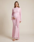 Pink lace maternity maxi dress with high neck, bell sleeves and draped lace panel, shown on a pregnant model in studio.
