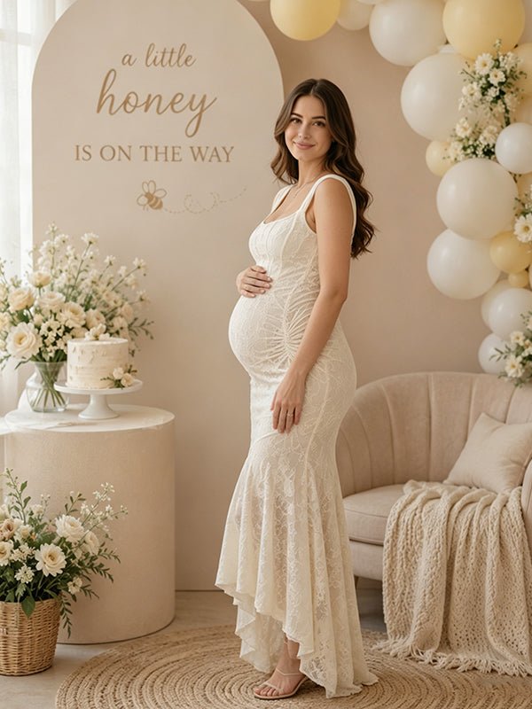 Side view of ivory lace maternity maxi dress with square neck, ruched bodice and high-low ruffle mermaid hem, designed for baby shower.