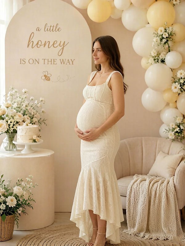 Side view of ivory lace maternity maxi dress with square neck, ruched bodice and high-low ruffle mermaid hem, designed for baby shower.