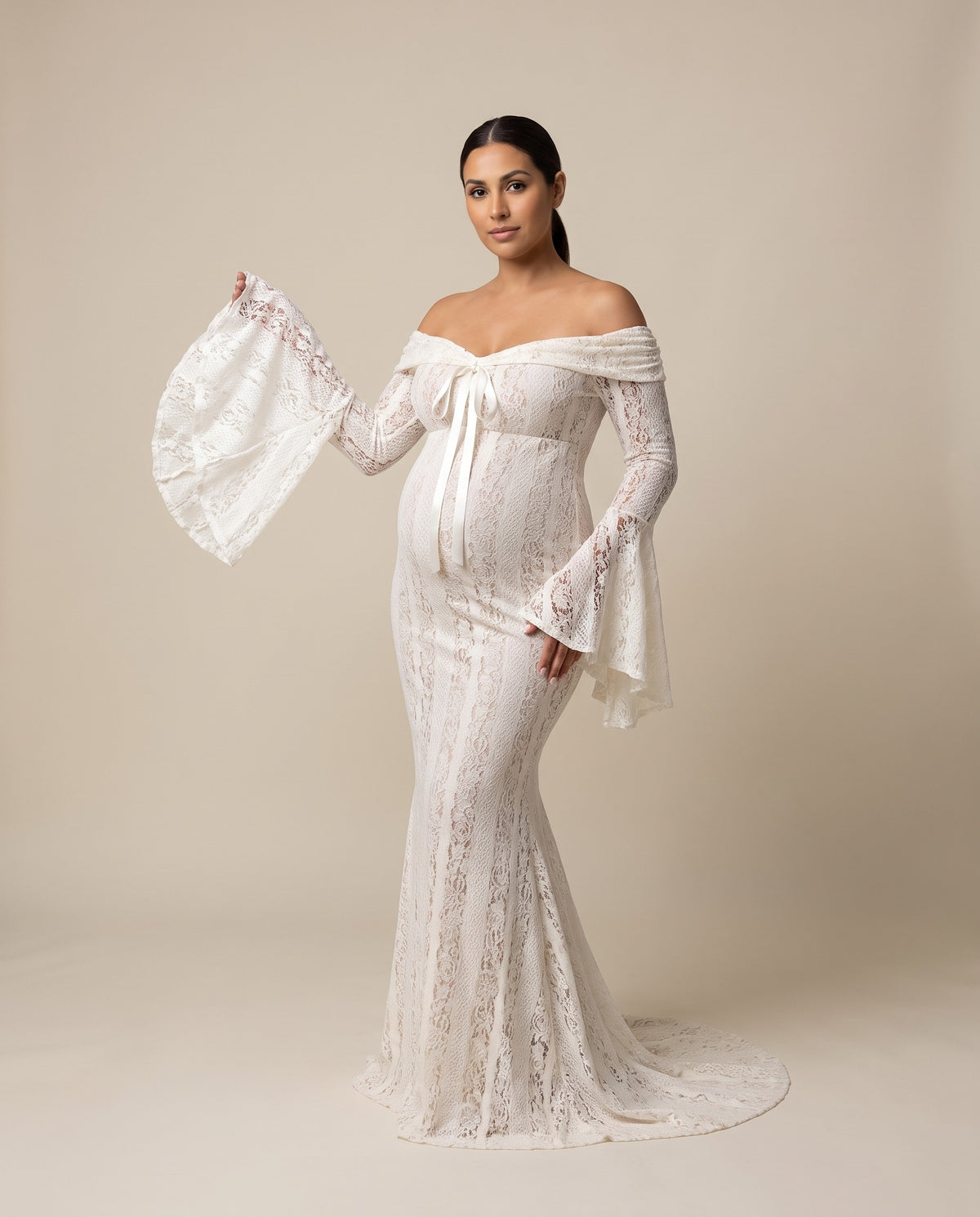 Ivory lace maternity maxi dress with off-shoulder neckline, bell sleeves and tie front, designed for maternity photoshoots.