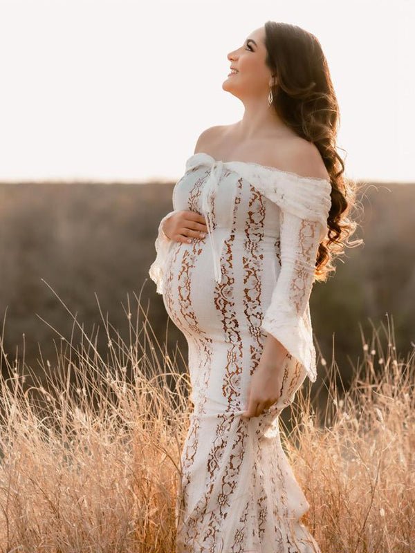 Ivory lace maternity maxi dress with off-shoulder tie-front neckline, bell sleeves and mermaid hem, designed for maternity photoshoot.