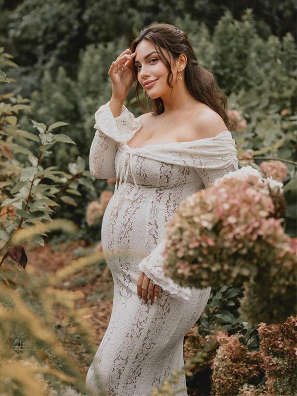 Ivory lace maternity maxi dress with off-shoulder tie-front neckline, bell sleeves and mermaid hem, designed for maternity photoshoot.