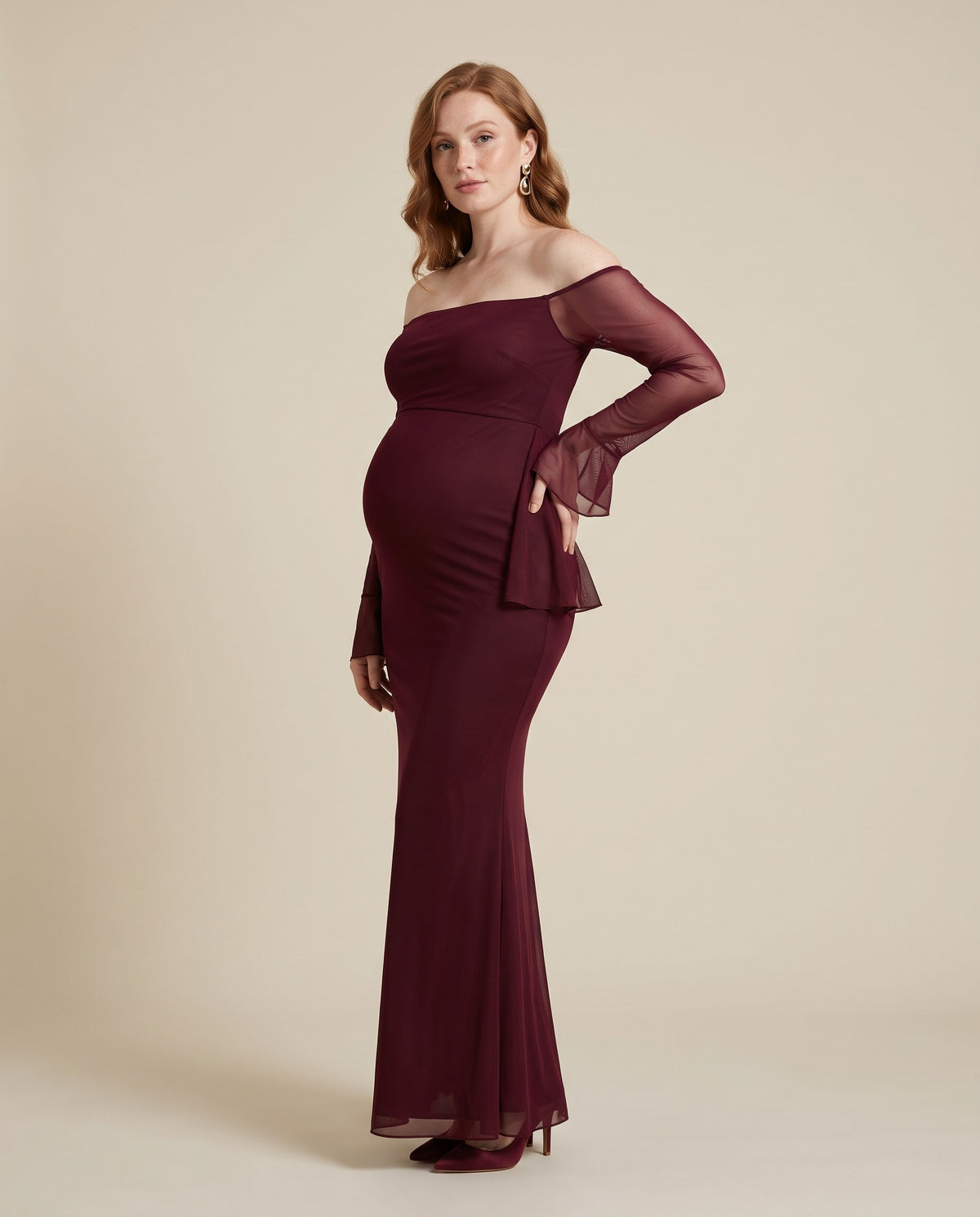Burgundy mesh maternity maxi dress with off-shoulder neckline and mermaid hem, designed for evening maternity photoshoots.