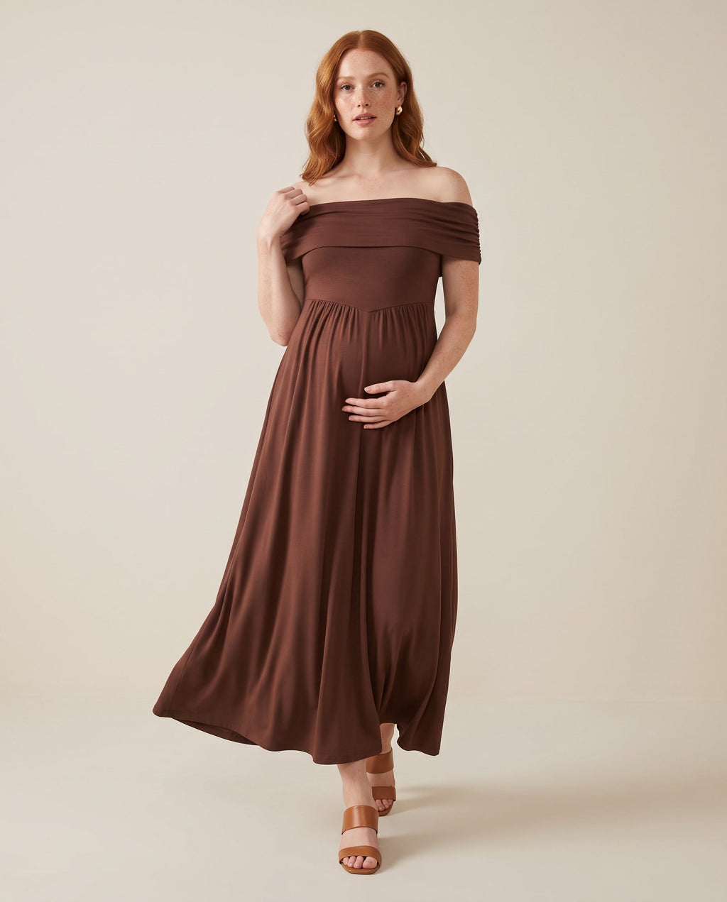 Brown off-shoulder maternity maxi dress with smocked bodice and flowing skirt, designed for baby showers.