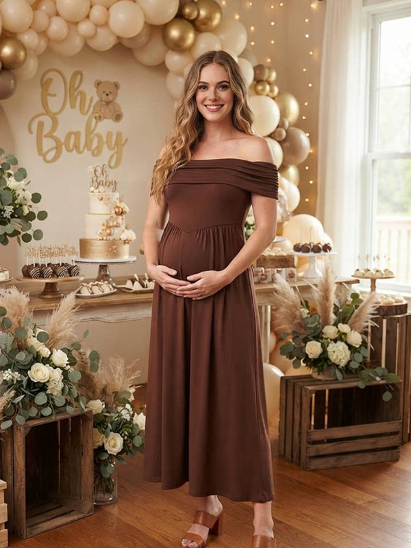 Brown maternity maxi dress with ruched off-shoulder neckline, smocked high waist and flowy skirt, designed for baby shower.