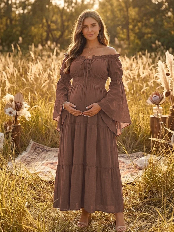 Brown boho maternity maxi dress with off-shoulder smocked bodice, bell sleeves and tiered skirt, designed for maternity photoshoot.