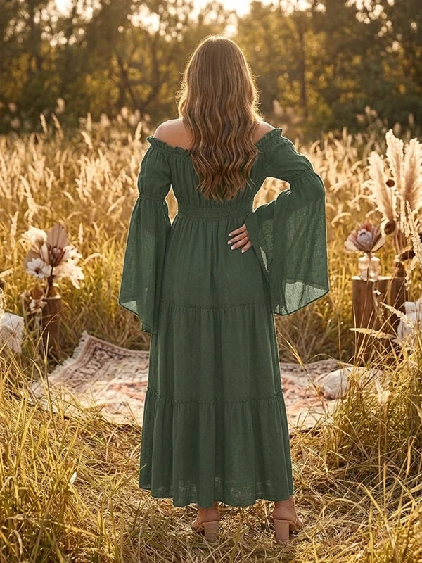 Back view of forest green boho maternity maxi dress with off-shoulder smocked bodice, bell sleeves and tiered skirt, designed for maternity photoshoot.
