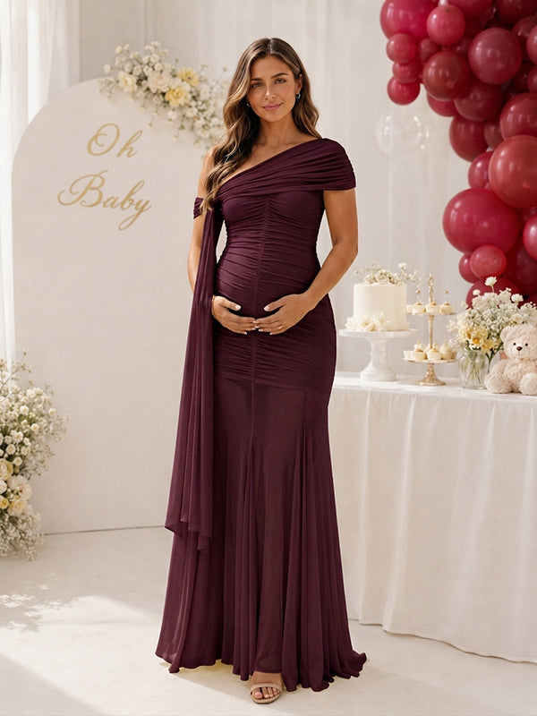 Burgundy ruched mesh maternity maxi dress with one-shoulder drape and sheer skirt, designed for baby shower.