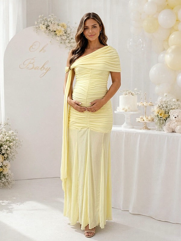 Yellow ruched mesh maternity maxi dress with one-shoulder drape and sheer skirt, designed for baby shower.