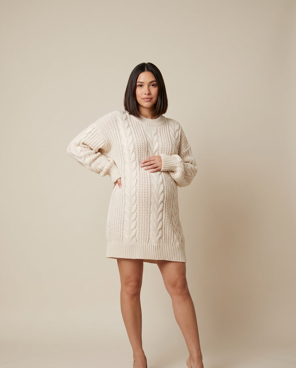 Cream oversized cable knit maternity mini sweater dress with long sleeves, designed for everyday autumn and winter wear.