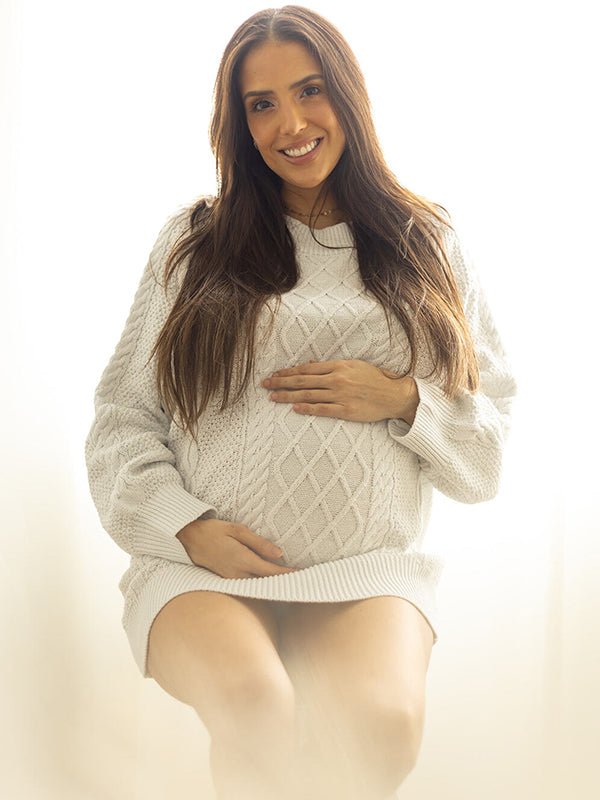 Cream white oversized cable knit maternity mini sweater dress with crew neck and balloon sleeves, designed for everyday wear.