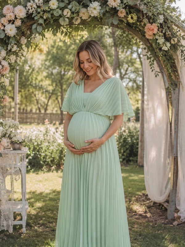 Mint green pleated chiffon maternity maxi dress with V-neck and flutter sleeves, designed for maternity photoshoot.