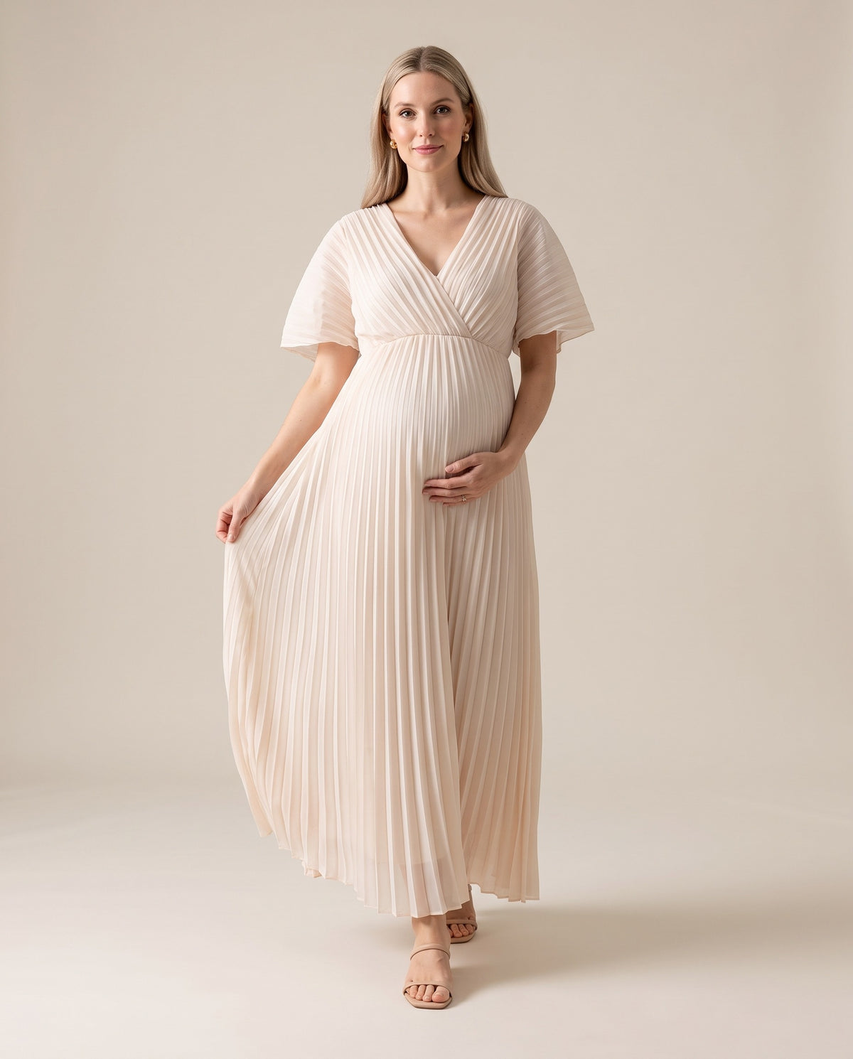 White pleated chiffon maternity maxi dress with flutter sleeves, designed for beach maternity photoshoots.
