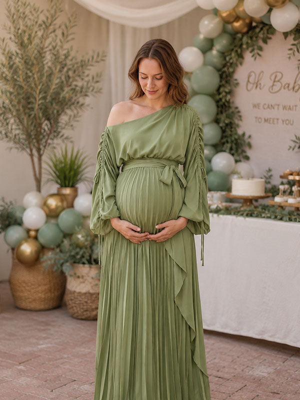 Sage green pleated maternity maxi dress with one-shoulder neckline, ruched drawstring sleeves and tie waist, designed for baby shower.