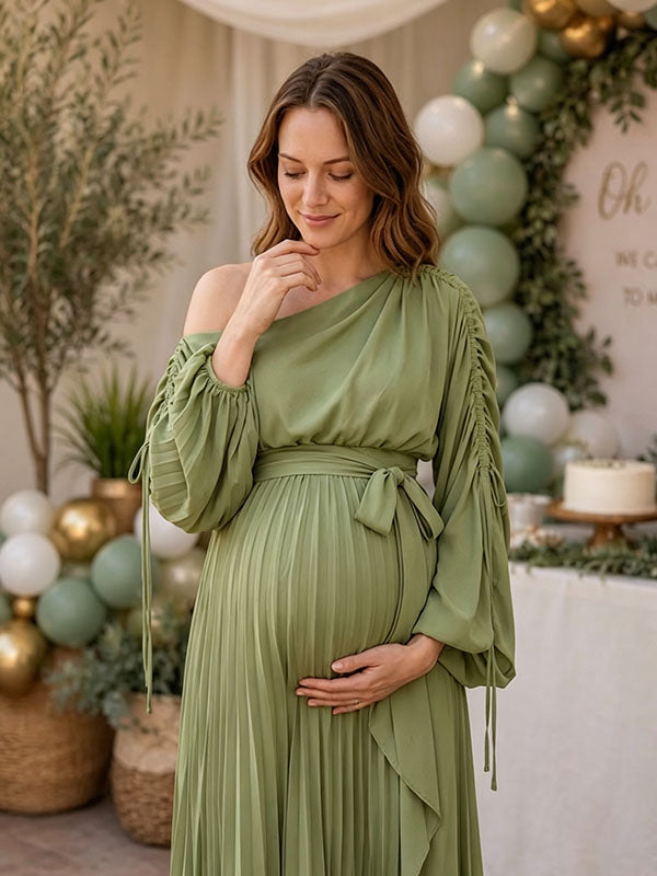 Sage green pleated maternity maxi dress with one-shoulder neckline, ruched drawstring sleeves and tie waist, designed for baby shower.