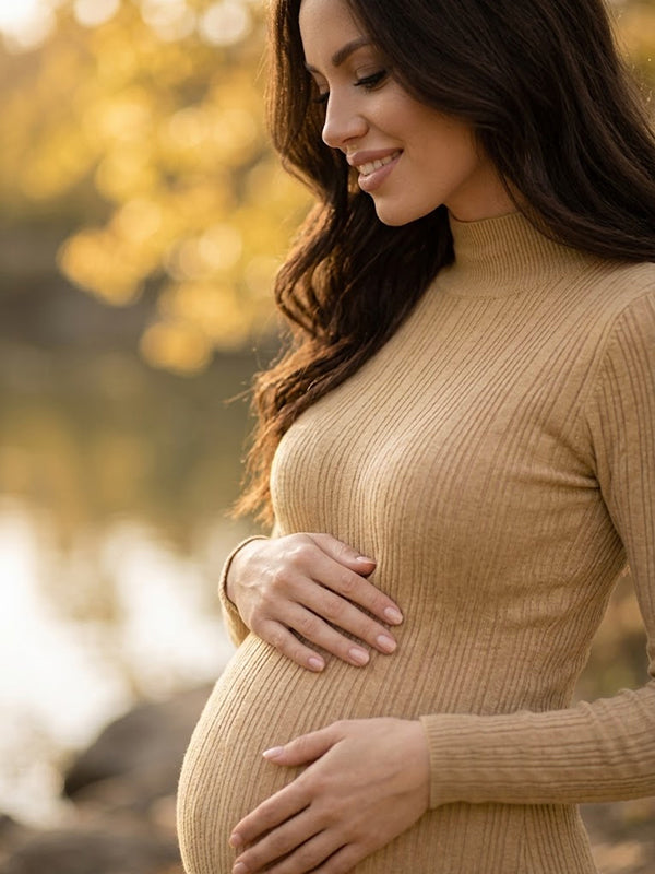 Close-up of khaki ribbed knit maternity midi dress with mock neck, designed for maternity photoshoot.