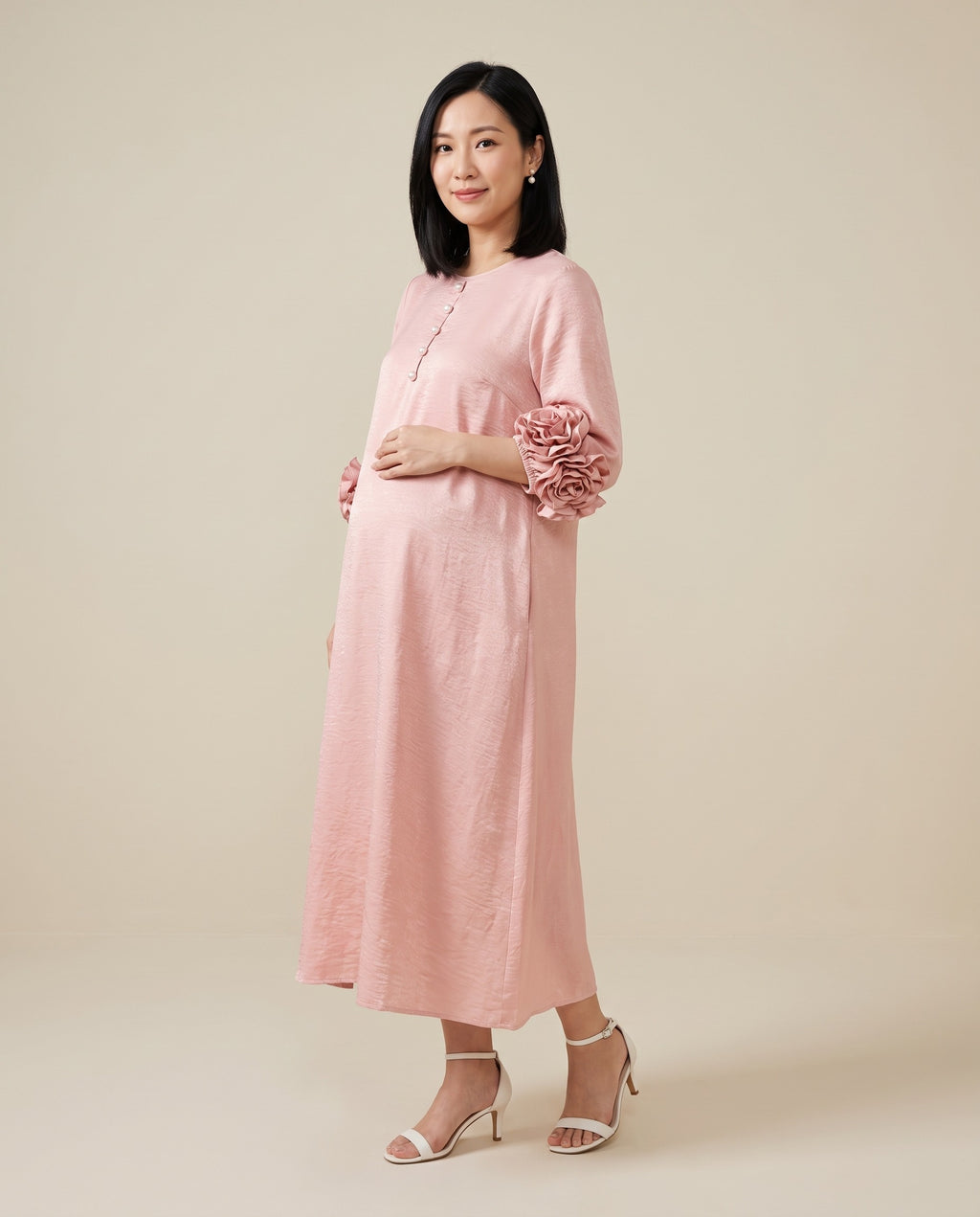 Pink maternity midi dress with rosette cuffs and button front, designed for baby shower and everyday wear.
