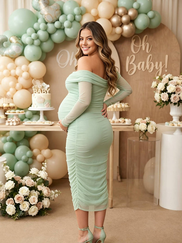 Back view of mint green ruched mesh maternity midi dress with off-shoulder neckline and sheer long sleeves, designed for baby shower.