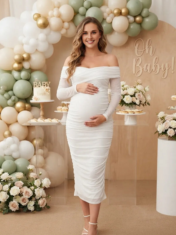 White ruched mesh maternity midi dress with off-shoulder neckline and sheer long sleeves, designed for baby shower.